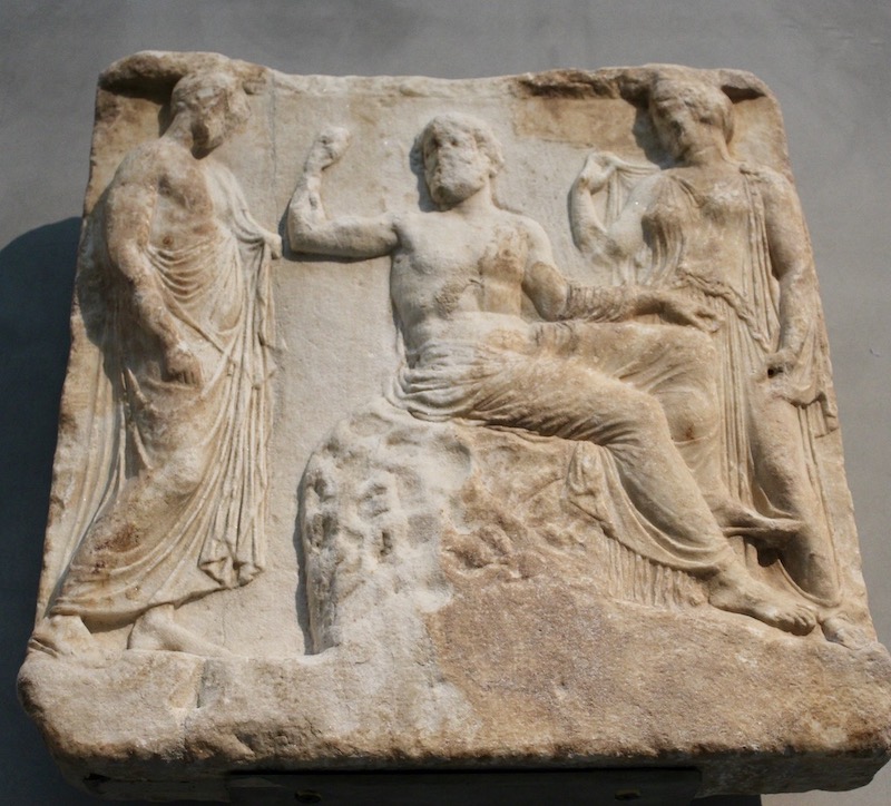 Asklepios sits between his daughter Hygieia and a man, Epidauros