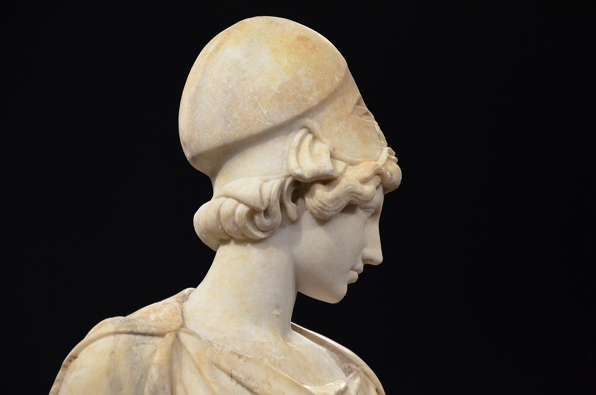 Statue: head and shoulders view of Athena, with helmet, looking down and away from us