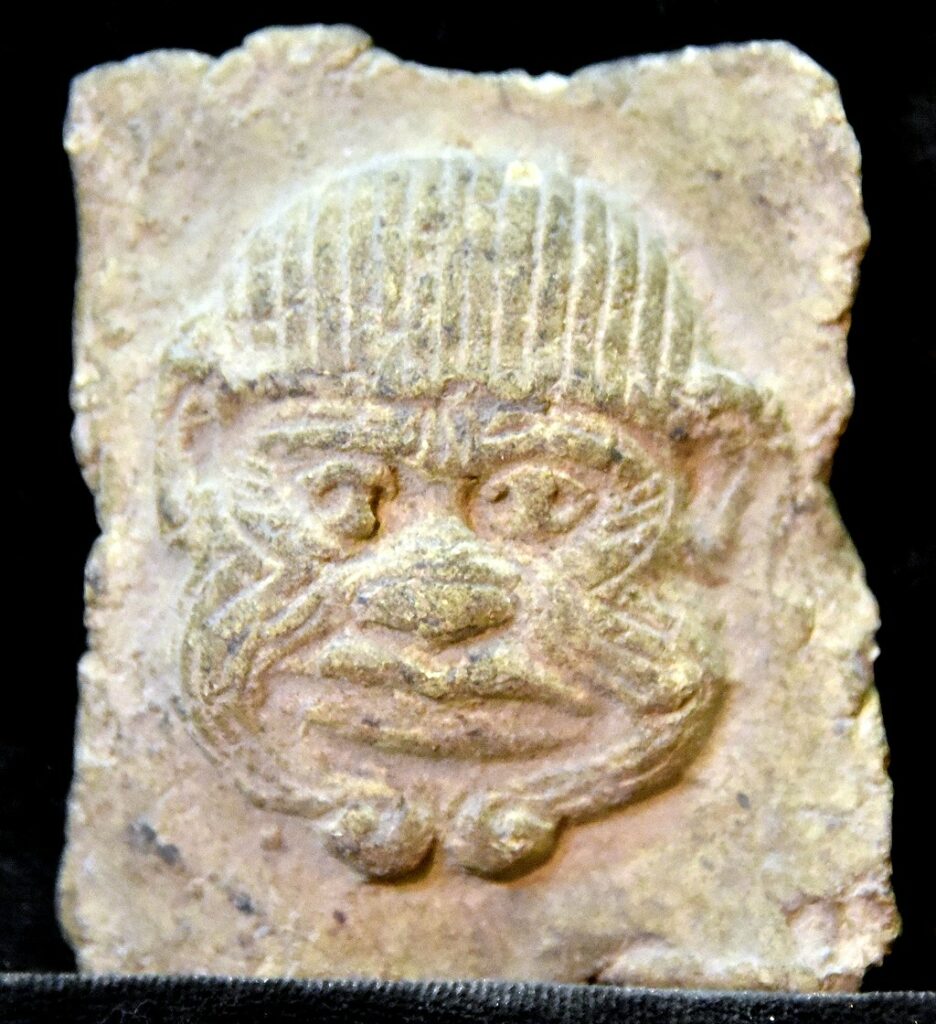 Terracotta plaque: Humbaba. Fierce looking head facing straight at the viewer